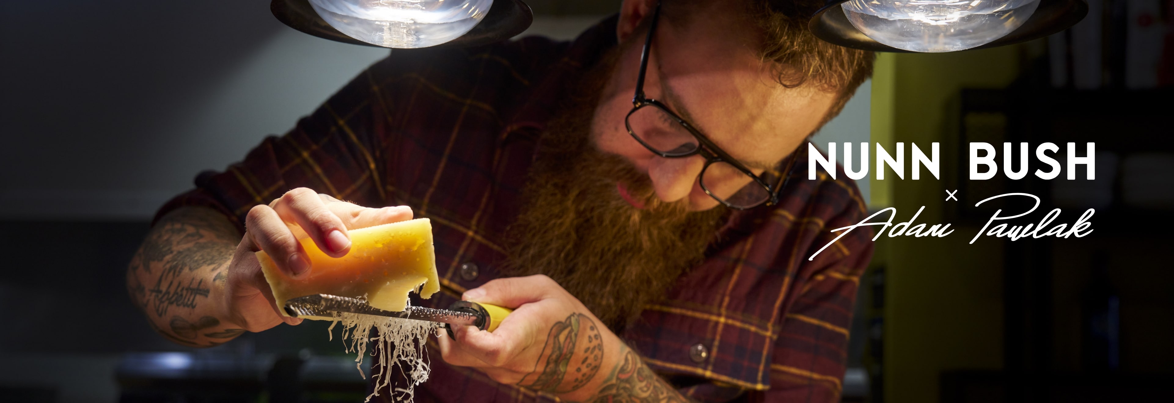 Image feaures Chef Adam Pawlak grating parmesan cheese. 